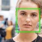 A close-up of a woman signing in with facial recognition.