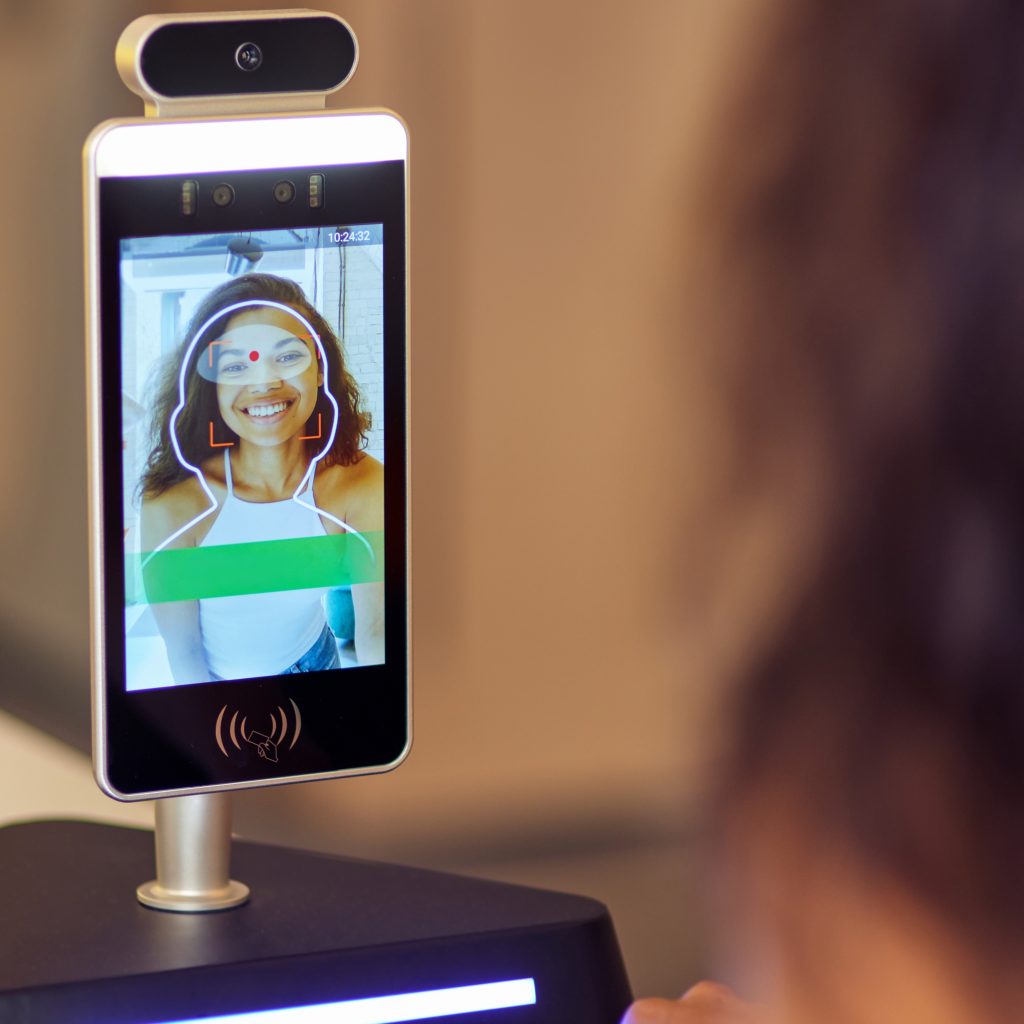 Woman uses facial recognition technology to get her face scanned for registration.